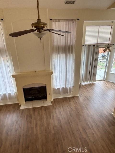 unfurnished living room featuring dark hardwood / wood-style floors and ceiling fan