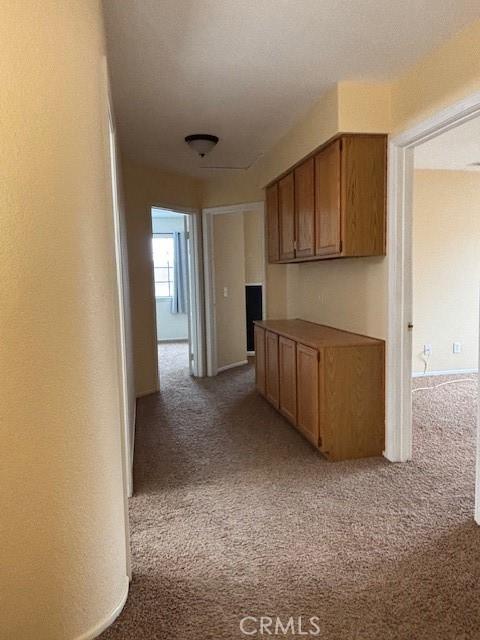 hallway featuring light colored carpet