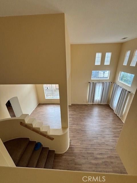 additional living space with hardwood / wood-style flooring and a high ceiling