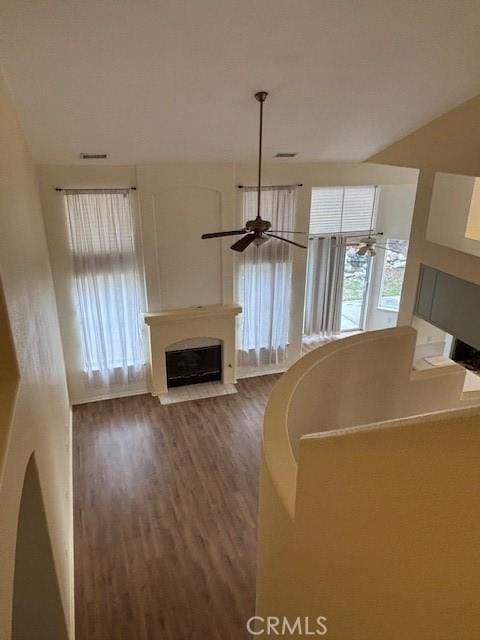 unfurnished living room with dark hardwood / wood-style floors and ceiling fan