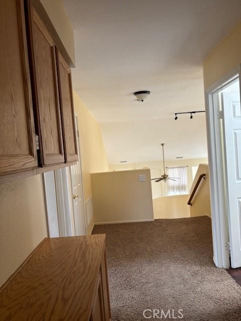 hallway featuring dark colored carpet