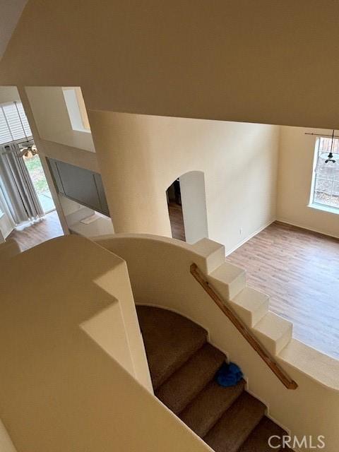 stairs with lofted ceiling and hardwood / wood-style floors