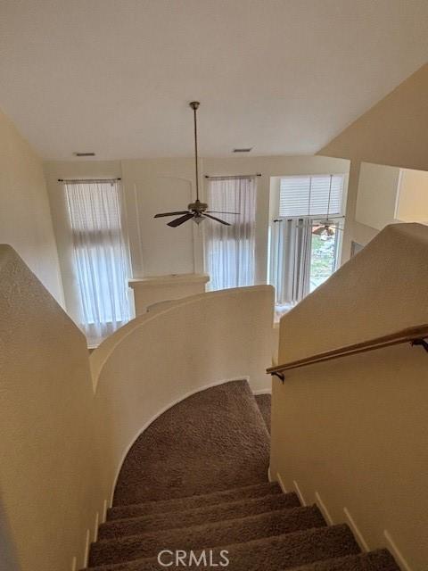 stairs featuring ceiling fan