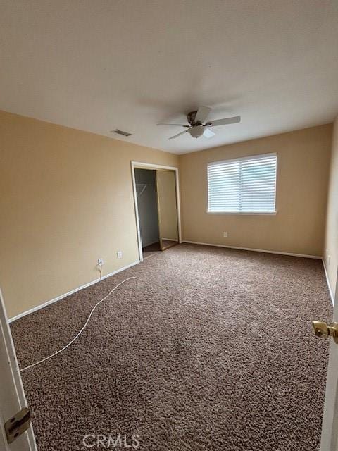 unfurnished bedroom featuring ceiling fan, a closet, and carpet