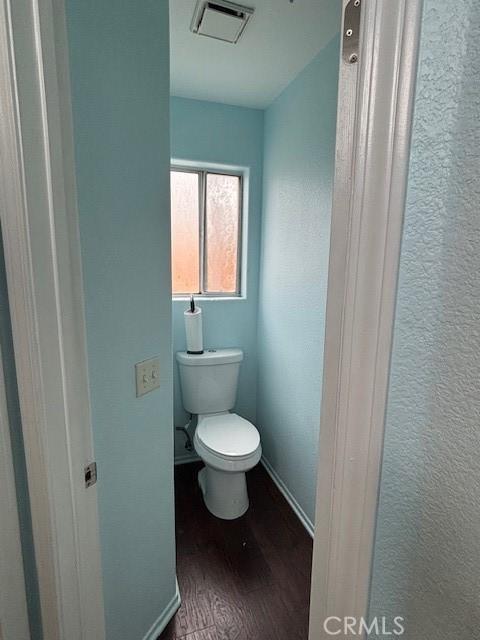 bathroom featuring wood-type flooring and toilet