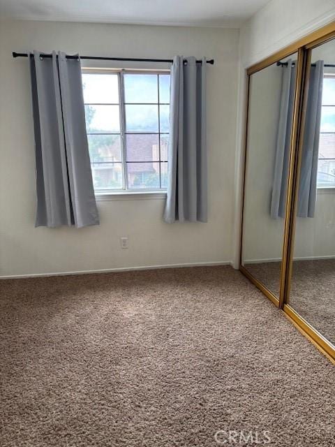 unfurnished bedroom with carpet flooring and a closet