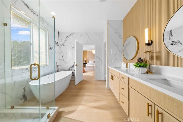 bathroom with vanity, shower with separate bathtub, and hardwood / wood-style floors