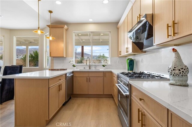 kitchen with extractor fan, appliances with stainless steel finishes, sink, and light brown cabinetry