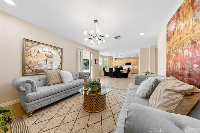 living room featuring a notable chandelier and light wood-type flooring