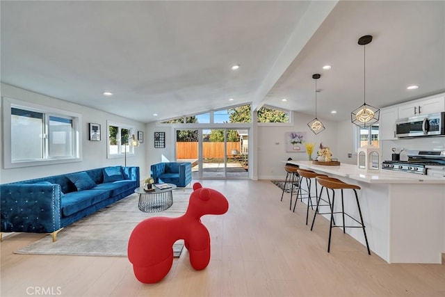 living room with lofted ceiling with beams and light hardwood / wood-style flooring