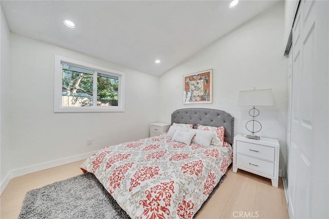 bedroom with vaulted ceiling and light hardwood / wood-style floors