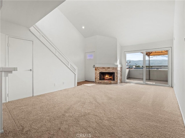 unfurnished living room with high vaulted ceiling and carpet floors