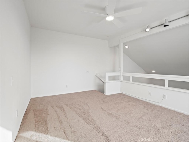 spare room featuring vaulted ceiling, ceiling fan, and carpet