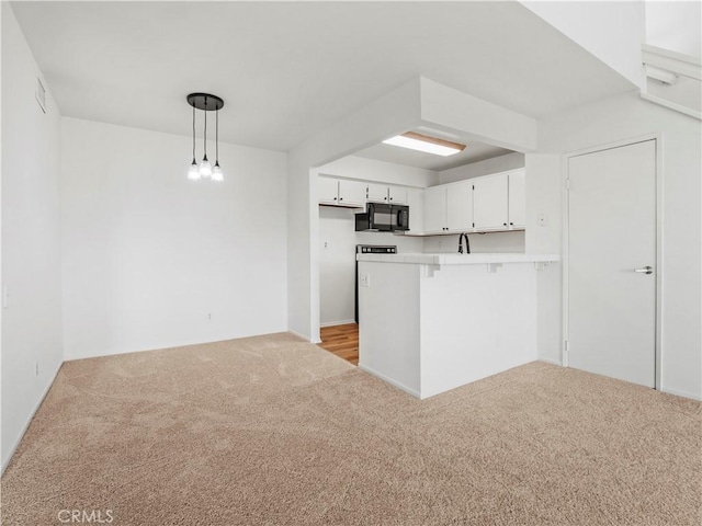 kitchen with hanging light fixtures, a kitchen breakfast bar, white cabinets, light colored carpet, and kitchen peninsula