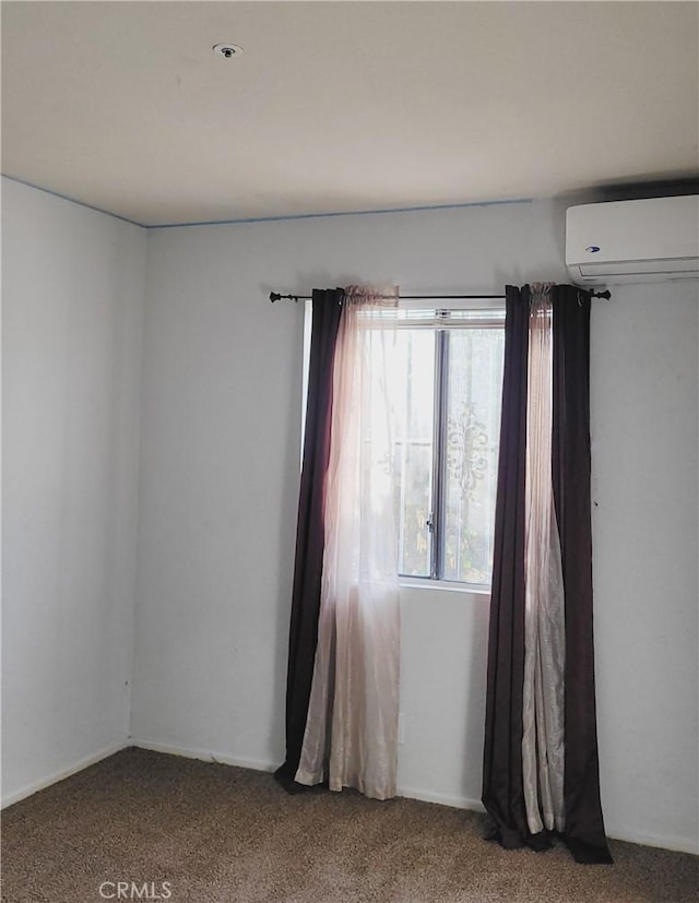 spare room featuring carpet floors and an AC wall unit