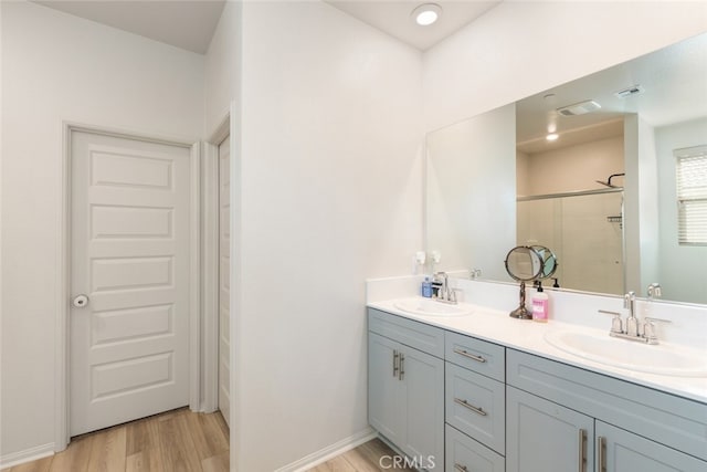 bathroom featuring vanity, hardwood / wood-style flooring, and a shower with door