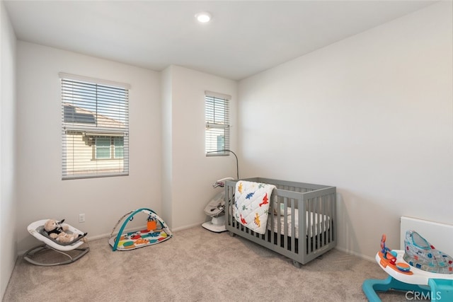 carpeted bedroom with a nursery area