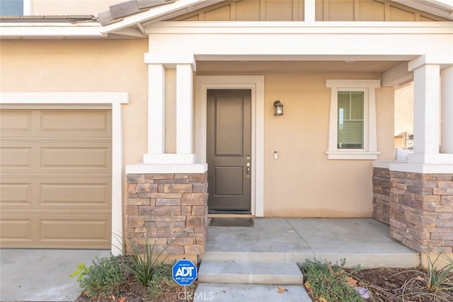 property entrance featuring a garage and a porch