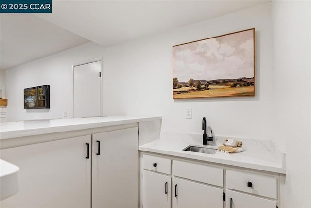 bar featuring sink and white cabinets