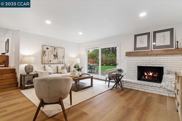 living room featuring a brick fireplace and light hardwood / wood-style flooring