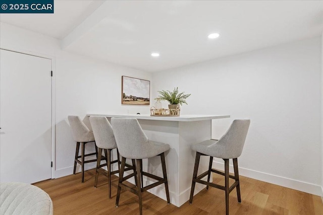 dining space featuring bar area and light hardwood / wood-style flooring