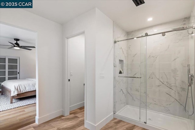 bathroom with hardwood / wood-style flooring, a shower with door, and ceiling fan