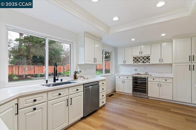 kitchen with wine cooler, sink, stainless steel dishwasher, a tray ceiling, and white cabinets