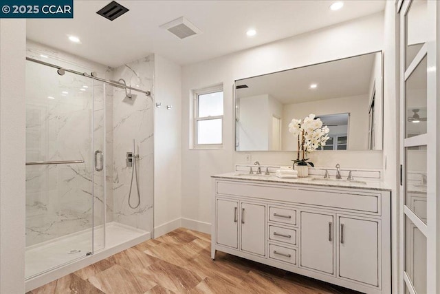 bathroom featuring hardwood / wood-style flooring, vanity, and a shower with shower door