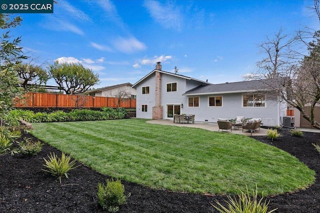 rear view of property with a patio, a yard, and central AC