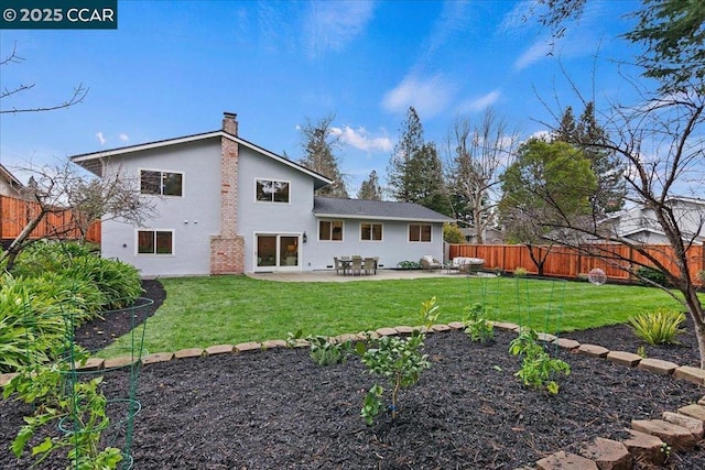 rear view of house with a patio and a lawn