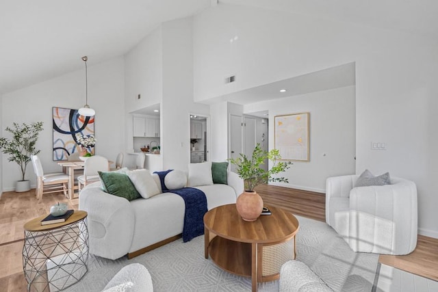 living room with high vaulted ceiling and light hardwood / wood-style floors