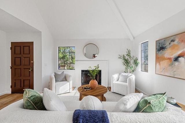 living room featuring vaulted ceiling with beams and hardwood / wood-style flooring