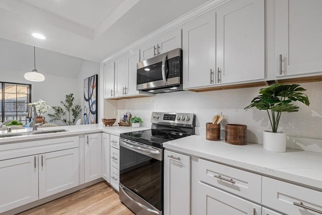 kitchen featuring appliances with stainless steel finishes, light hardwood / wood-style floors, sink, and white cabinets