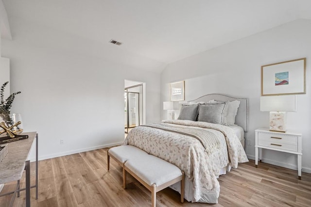 bedroom with lofted ceiling and light wood-type flooring