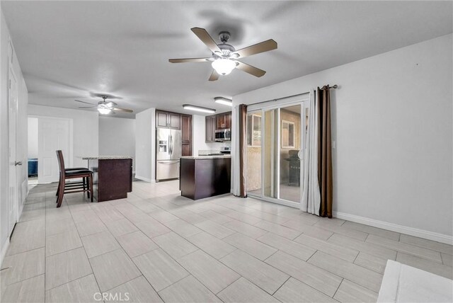 kitchen with a kitchen island, ceiling fan, and appliances with stainless steel finishes