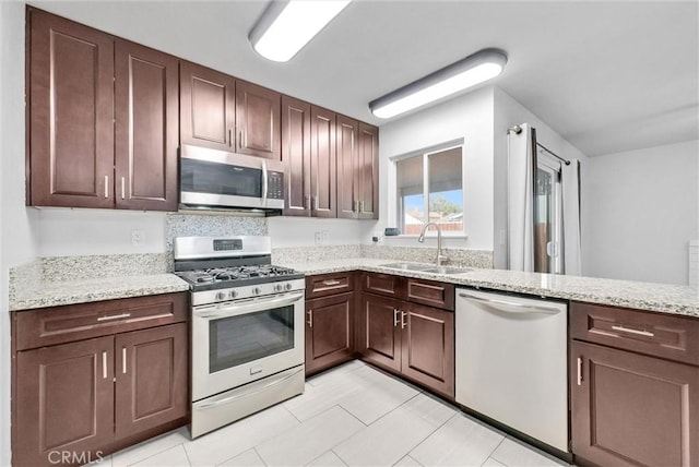 kitchen featuring sink, stainless steel appliances, and light stone countertops