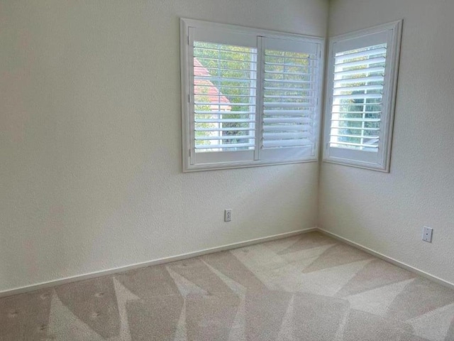 carpeted empty room featuring plenty of natural light