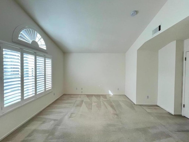 carpeted spare room with lofted ceiling