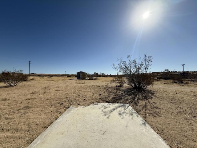 view of yard with a rural view and a storage unit