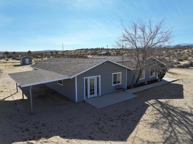 rear view of house with a storage shed