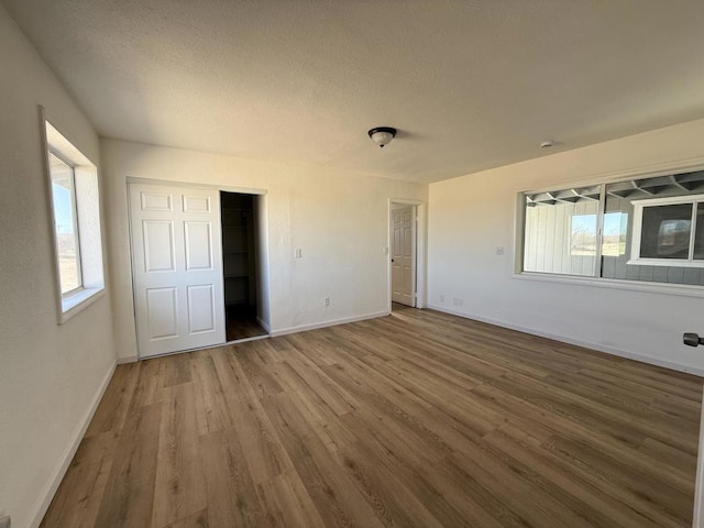 unfurnished bedroom featuring hardwood / wood-style flooring and a textured ceiling