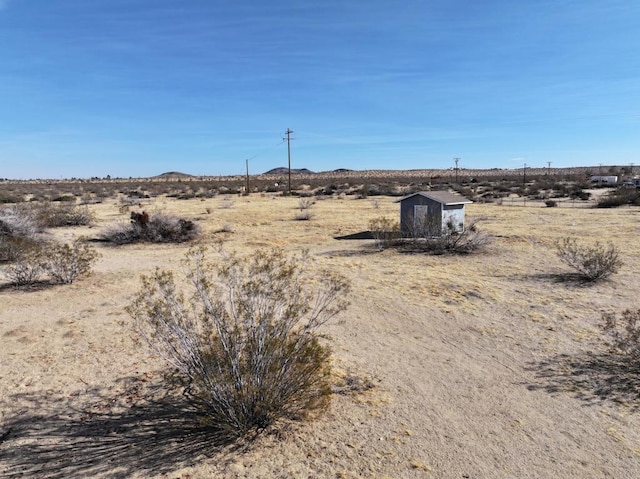 view of yard with a storage shed and a rural view