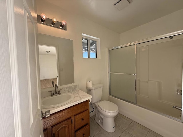 full bathroom featuring vanity, tile patterned floors, shower / bath combination with glass door, and toilet