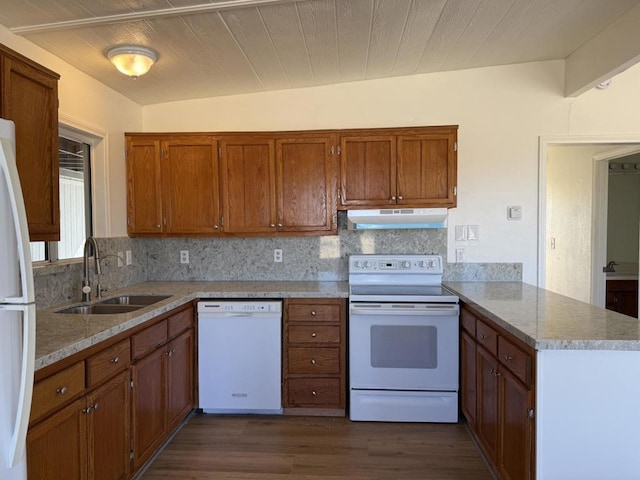 kitchen with tasteful backsplash, sink, white appliances, and kitchen peninsula