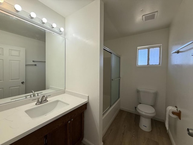 bathroom featuring walk in shower, vanity, toilet, and hardwood / wood-style flooring