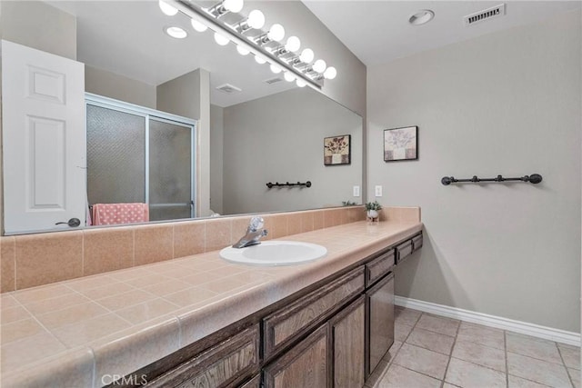 bathroom with vanity, tile patterned floors, and walk in shower