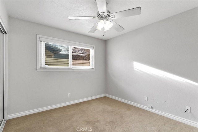 carpeted empty room featuring ceiling fan