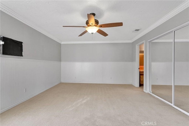 interior space featuring ceiling fan, light colored carpet, and ornamental molding