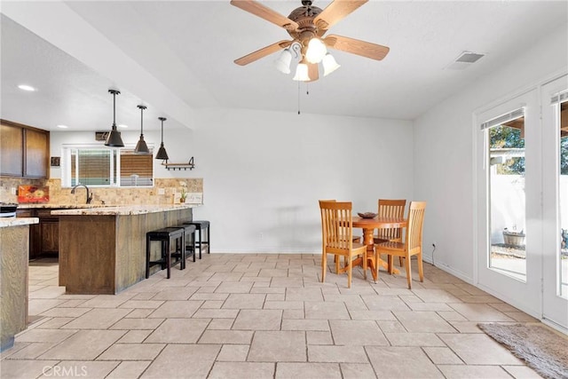 dining room featuring ceiling fan and sink