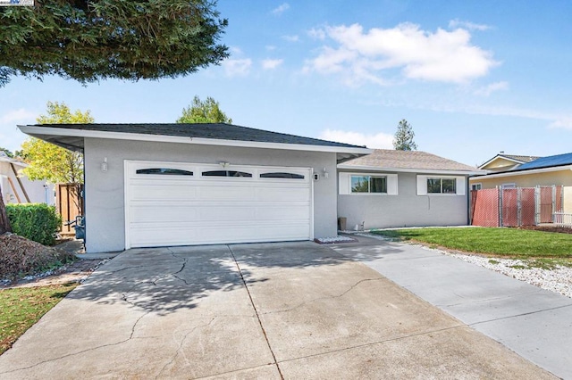 ranch-style home with a garage and a front lawn